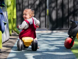 Two-and-half-year-old Maeve does a great job of riding on the blue bike lane in SIT Childcare’s recently refurbished and enlarged outdoor play space, which includes new features to increase 