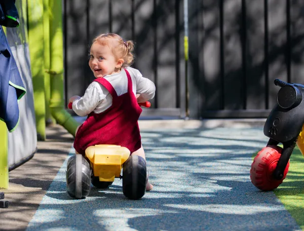 Two-and-half-year-old Maeve does a great job of riding on the blue bike lane in SIT Childcare’s recently refurbished and enlarged outdoor play space, which includes new features to increase 